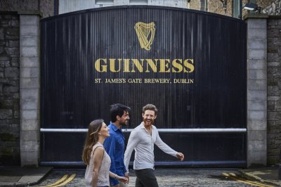 people walking in front of guinness factory