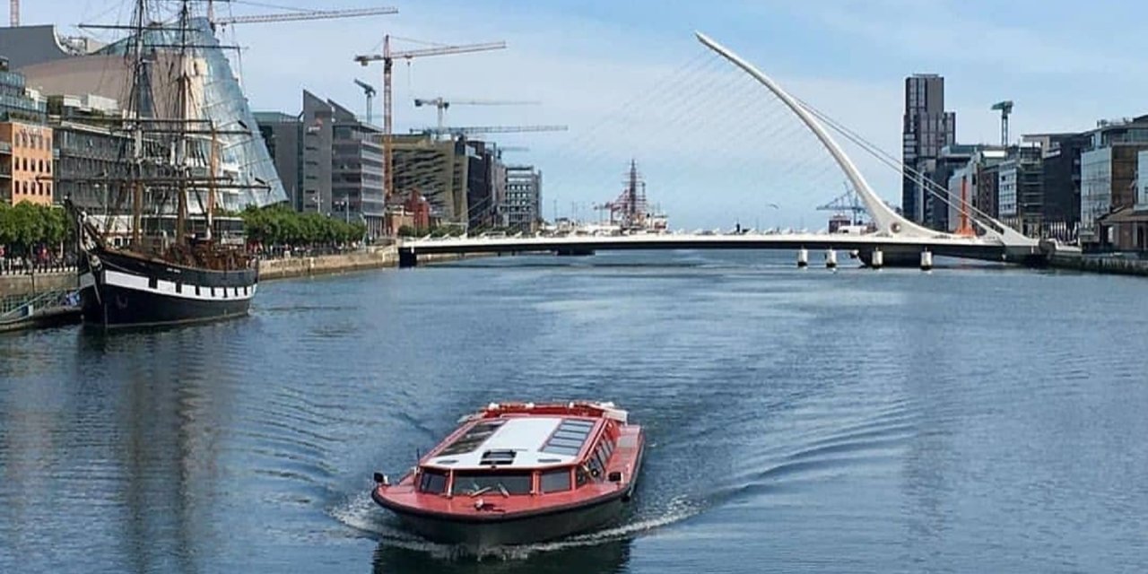 red boat on river with white bridge in background
